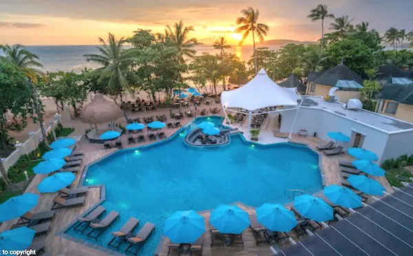 Pool area and beach at sunset at the Centara Grand Beach Resort & Villas.
