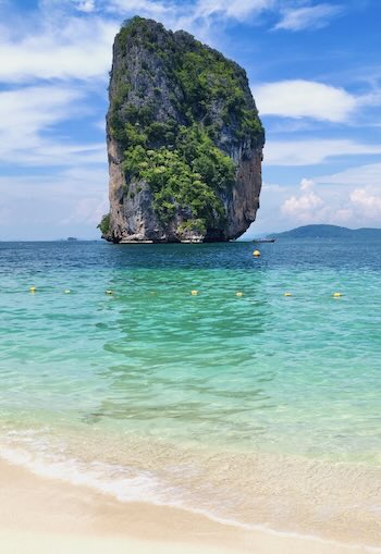 A solitary limestone karst jutting out of the Andaman Sea in the view from Ko Poda Island.