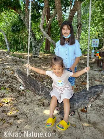 Two Thai children at the beach swing at Mu Ko Lanta National Park. © KrabiNature.com