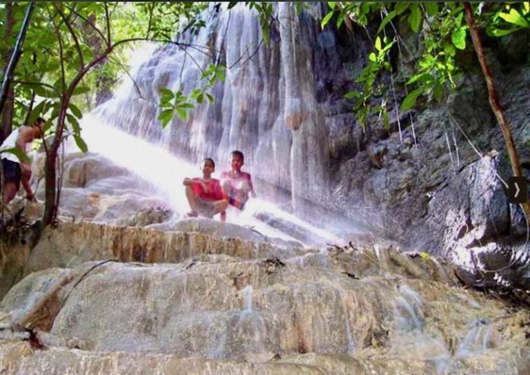 2 boys sitting on the limestone rock of a waterfall few in Krabi ever get to see. © KrabiNature.com