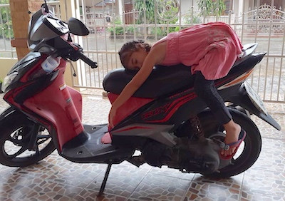Girl sleeping on motorbike in Krabi.