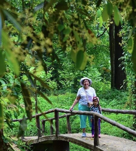 Tourists at Huay To Waterfall bridge in stunning scenery.